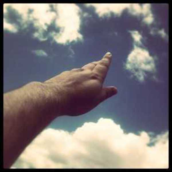 Photo of my hand reaching for the clouds