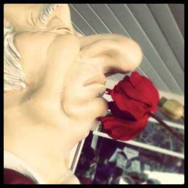 Photo of a statue of a man sniffing a flower